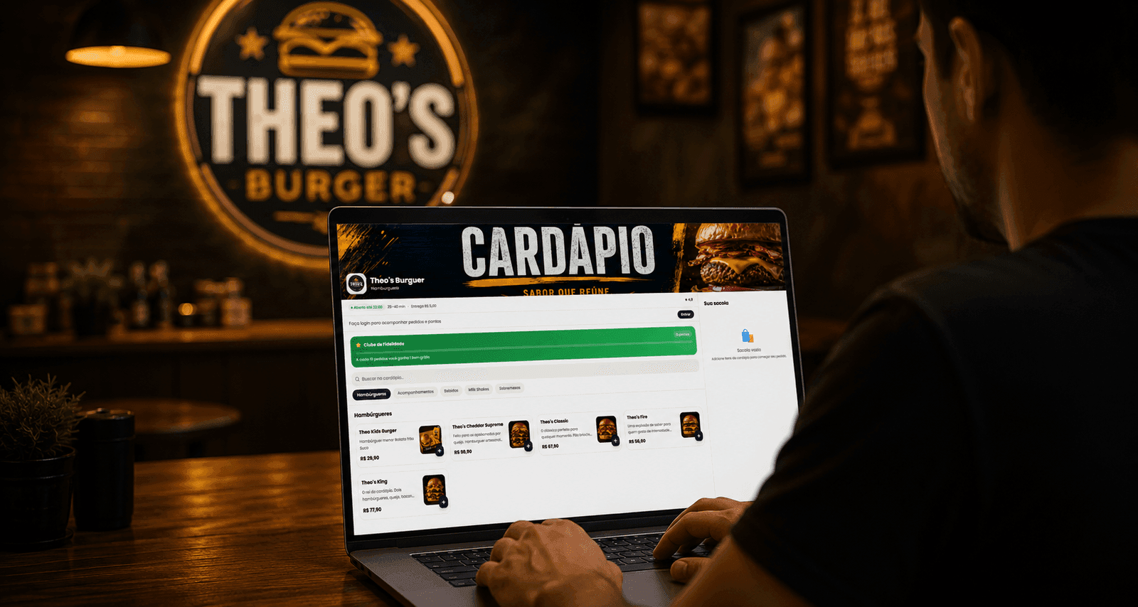 Dono de hamburgueria acompanhando o cardápio digital da Zupio no notebook, dentro do salão